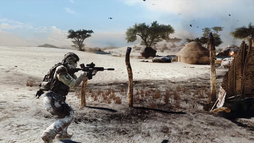 Tactical soldier aiming a rifle in a desert village with thatched huts, smoke, and birds under a hazy sky.