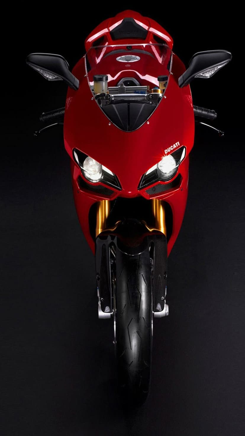 Red Ducati motorcycle front fairing with glowing headlights, golden forks, and carbon fiber accents.