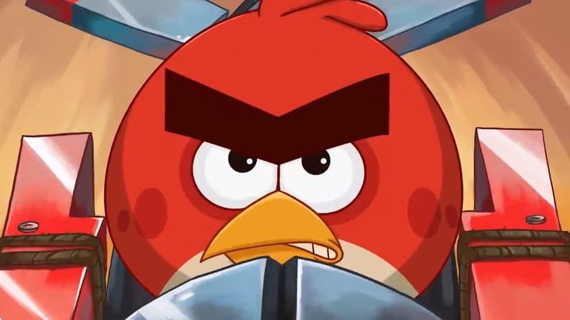Red bird with thick black eyebrows and angry expression inside a red and blue metallic mechanical vehicle.