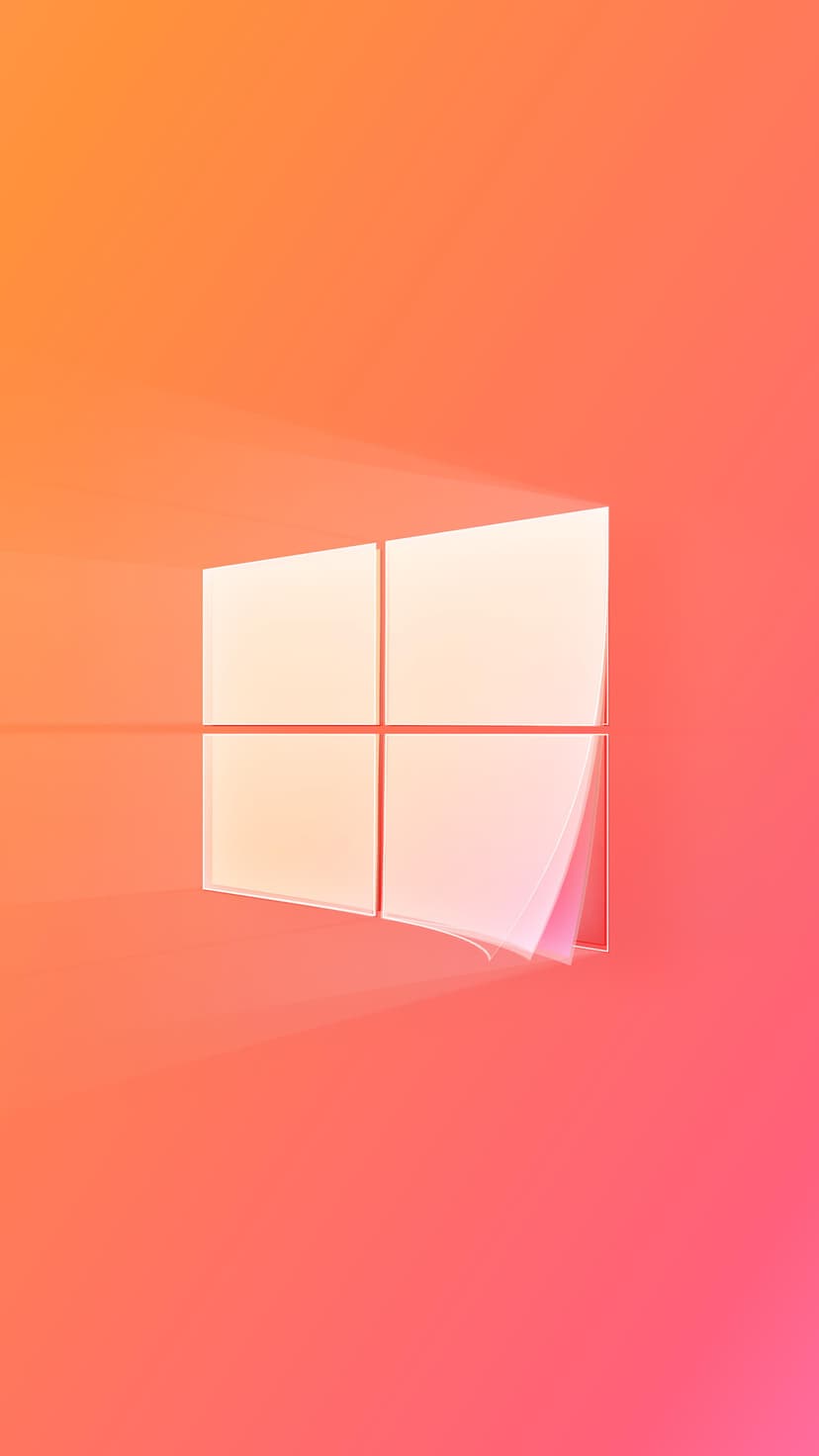 Windows 10 logo in glowing white translucent glass over a warm orange and pink gradient background with soft shadows