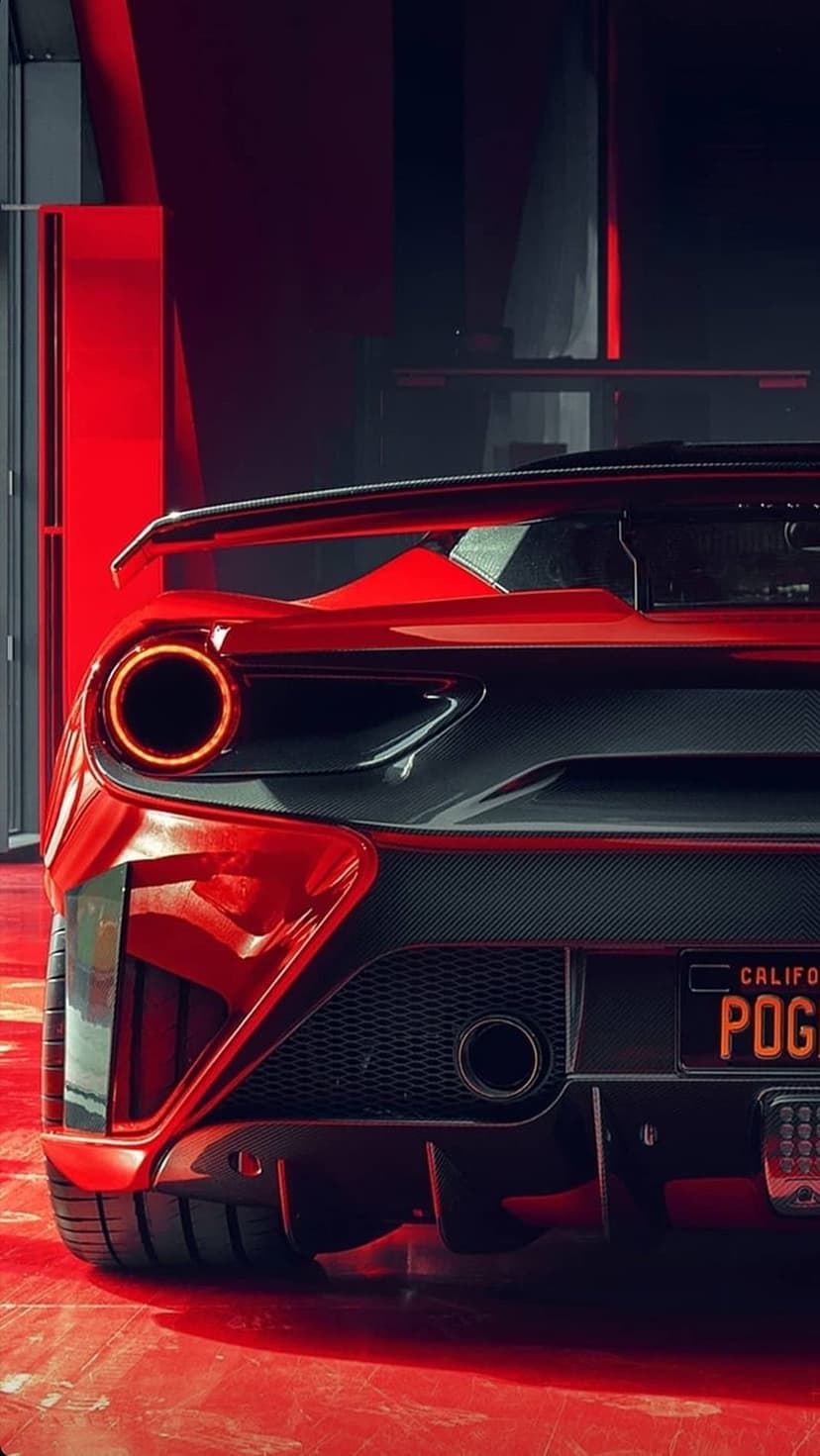 Red Ferrari tail lights glow above a California license plate with carbon fiber trim and floor reflections.