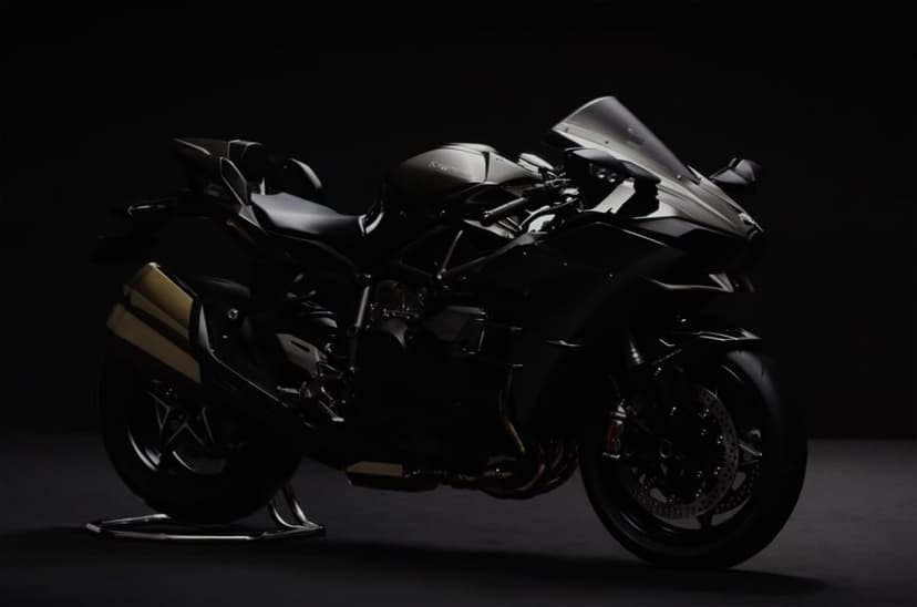 Black sports bike in a dark studio with dramatic rim lighting highlighting sleek aerodynamic fairings and wheels.
