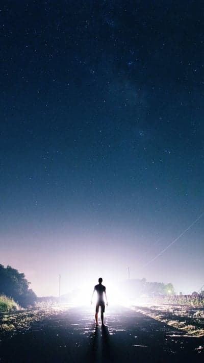 Beacon Under the Cosmos - A Figure Bathed in Light