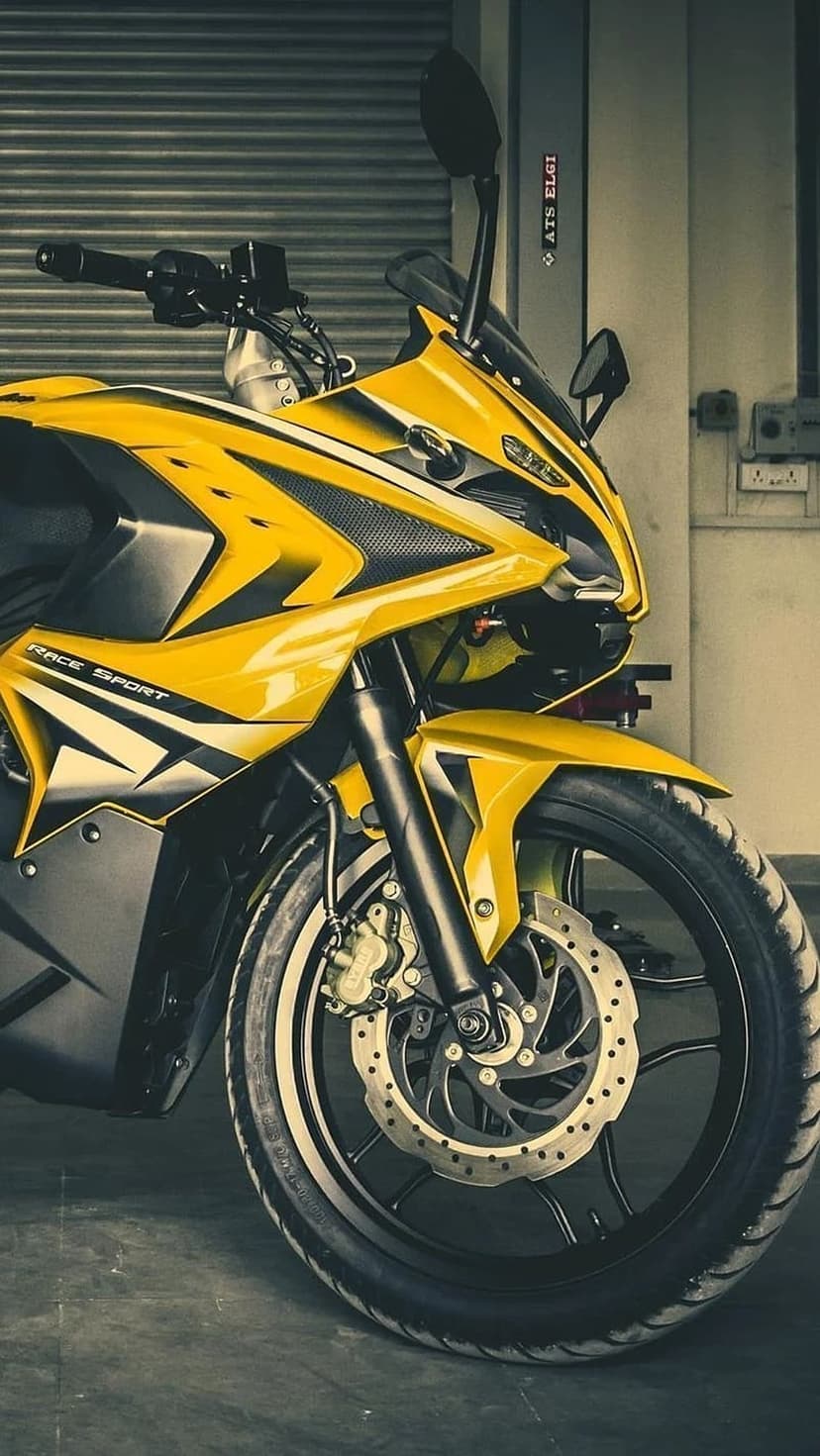 Yellow sports motorcycle front view highlights metallic disc brakes and suspension forks in a vertical shot.