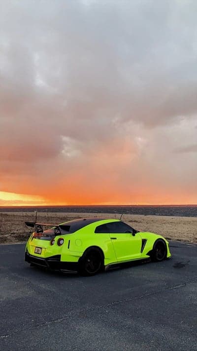 Vibrant Neon Nissan GT-R Sunset Coastal Mobile Wallpaper