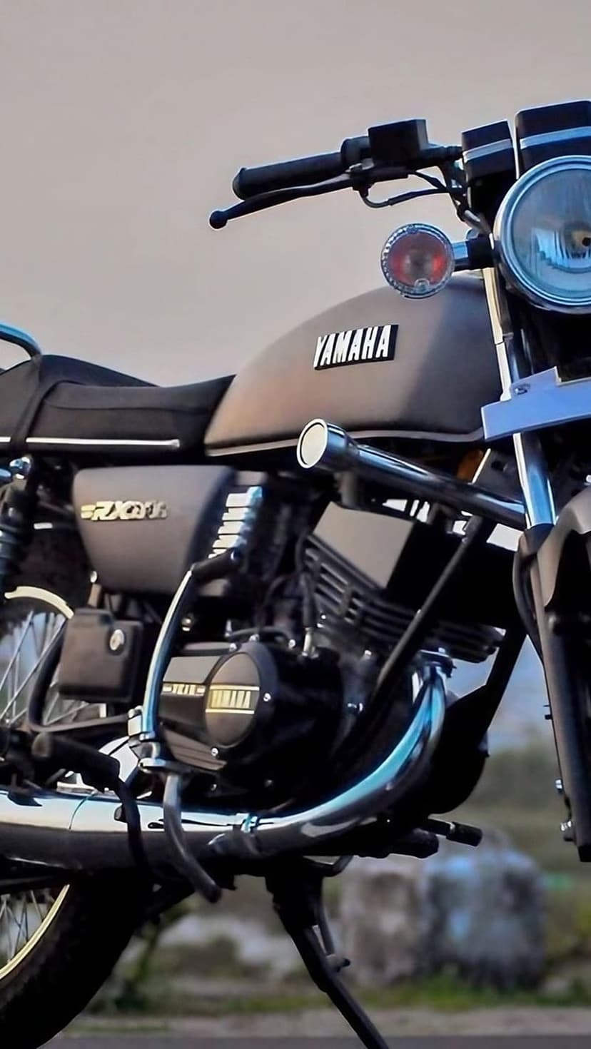 Yamaha RX135 motorcycle fuel tank and chrome engine components showcased in a detailed vertical close-up shot.