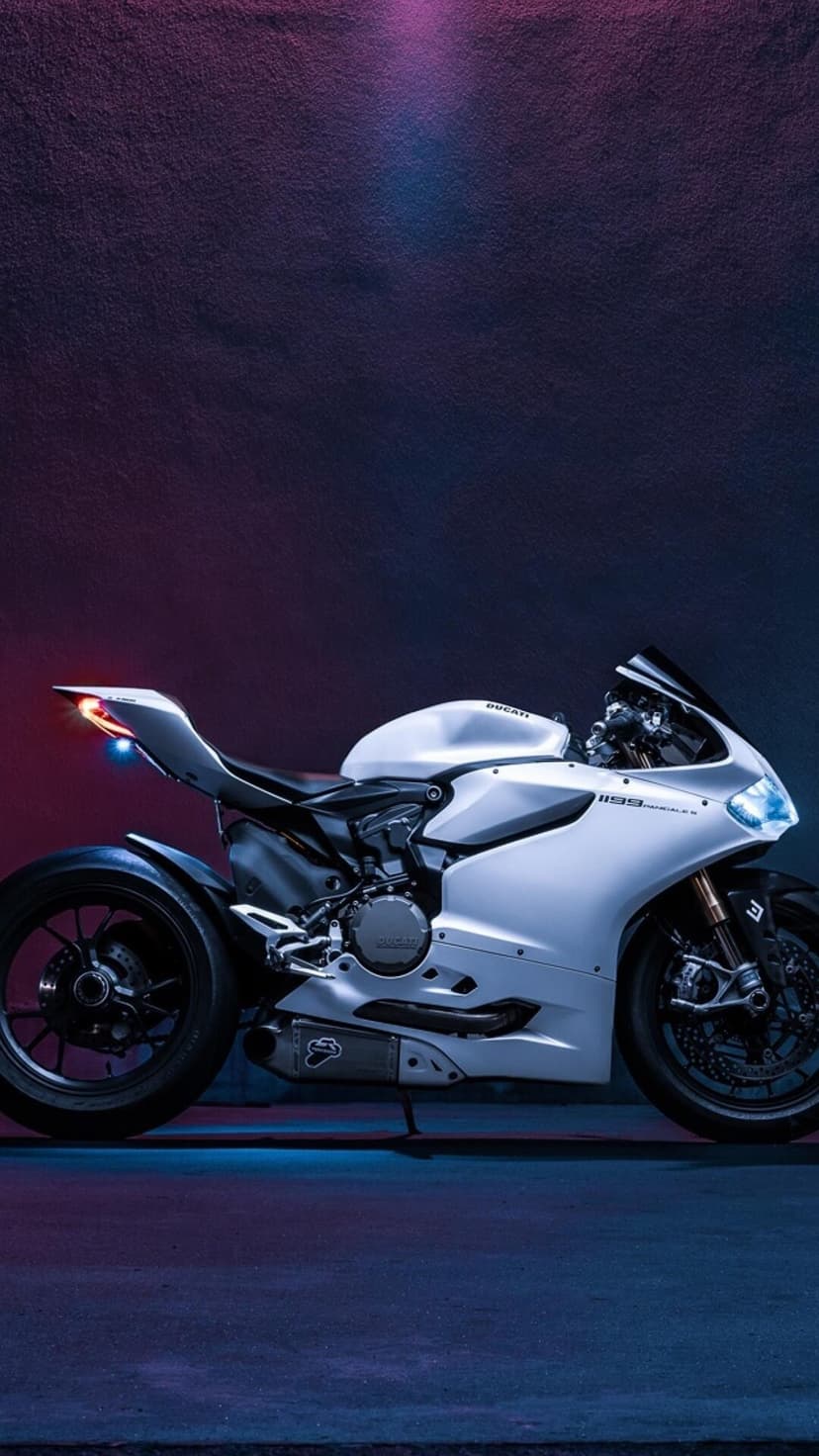 White Ducati motorcycle with purple and blue neon lighting highlights on the fairing and engine components.