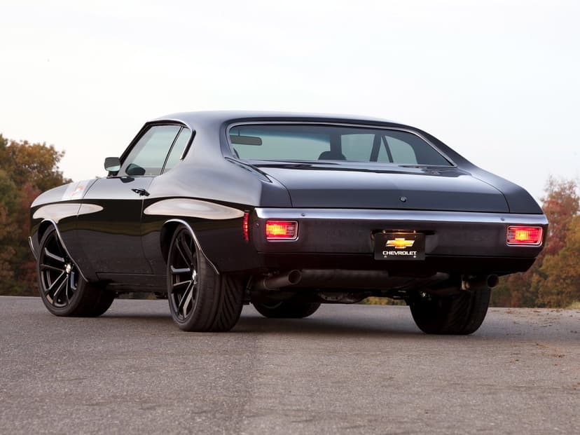 Black 1970 Chevrolet Chevelle SS with chrome bumpers and modern black wheels parked on a rural asphalt road.