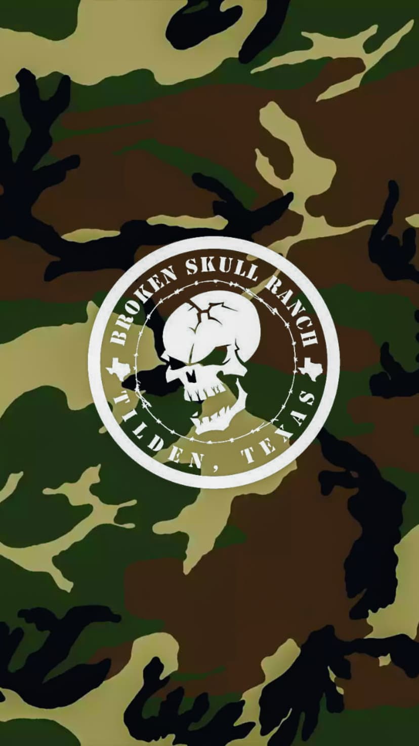 Cracked white skull surrounded by rusted barbed wire against a green, brown, and black woodland camouflage.