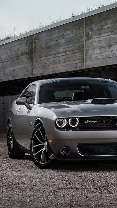 Sleek Silver Dodge Challenger parked by modern concrete building
