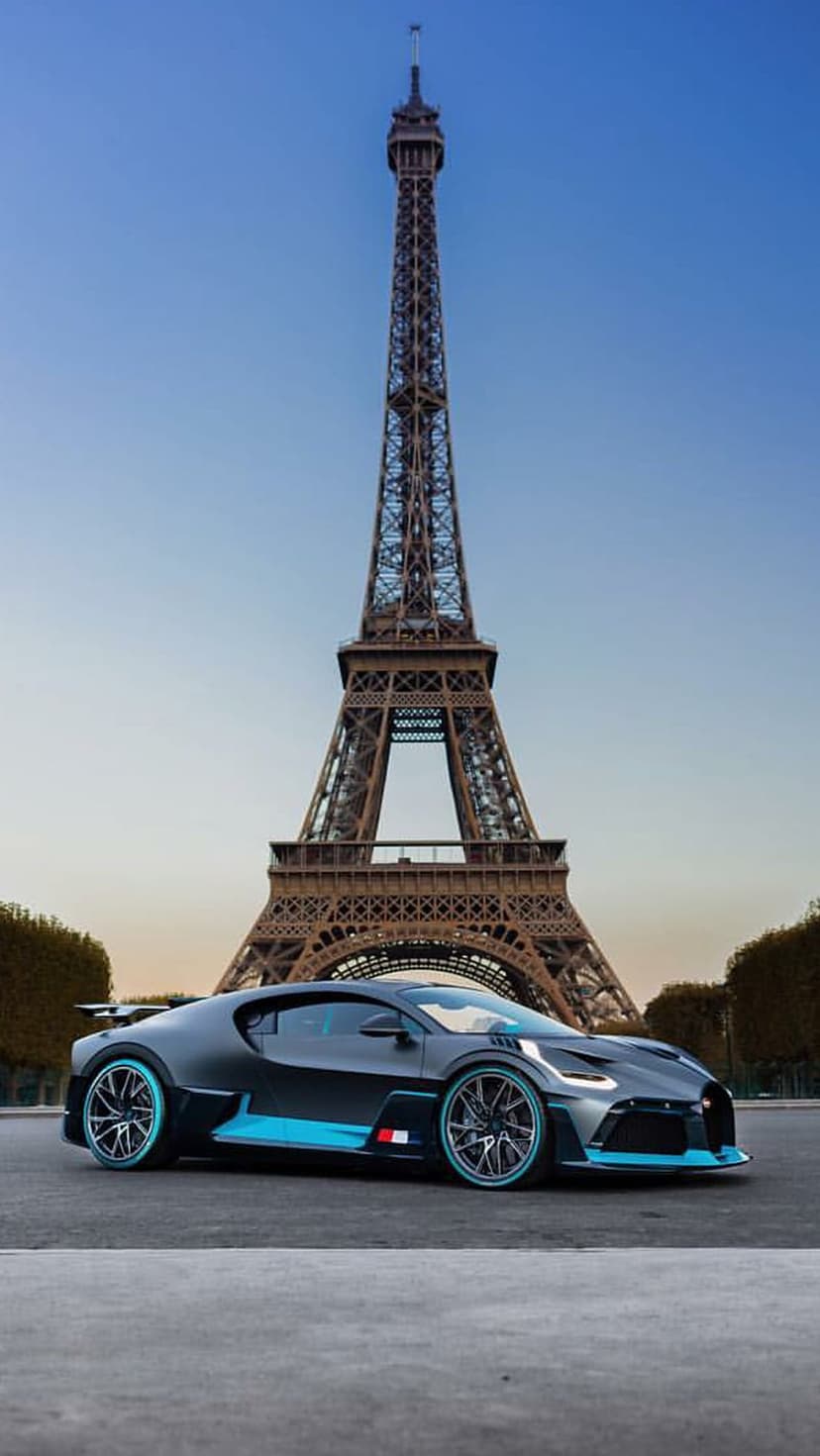 Bugatti Divo in matte black with blue trim parked on a Paris street with the Eiffel Tower in the background.