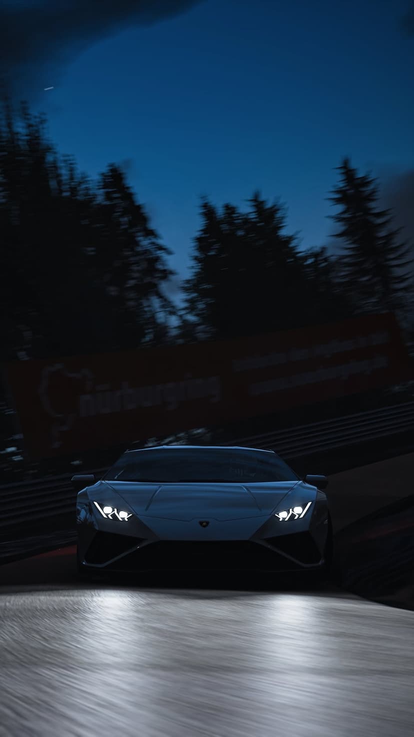 Modern sports car with glowing headlights speeds on a wet Nürburgring track at night under a wooded canopy.