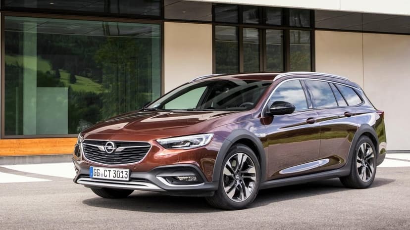 Brown Opel Insignia Country Tourer parked in front of a modern glass building with mountain reflections.