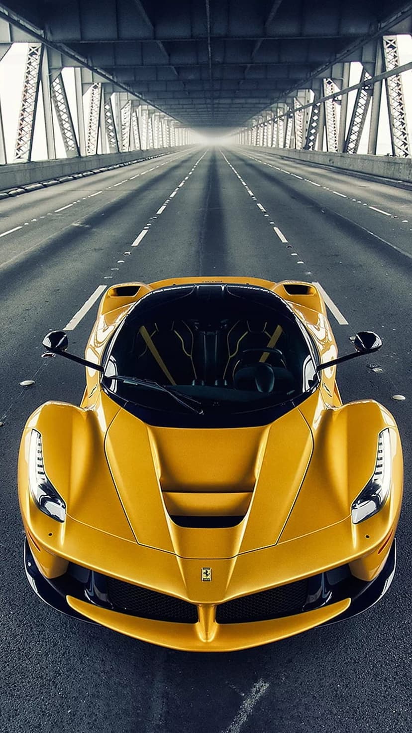 Yellow Ferrari supercar driving on a concrete highway beneath a massive bridge with motion blur on the road.