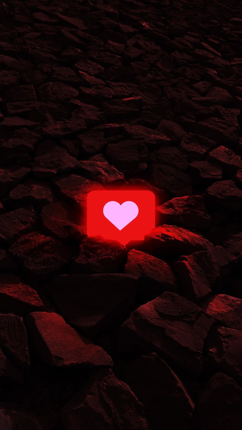 Glowing pink heart icon within a red neon square sits atop textured black volcanic stone formations.