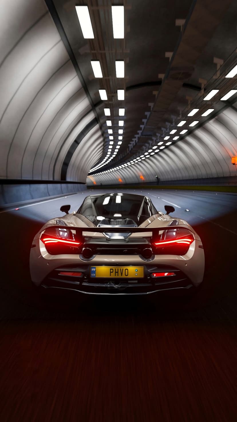 Beige luxury sports car with glowing red taillights speeding through a modern tunnel with rectangular ceiling lights.