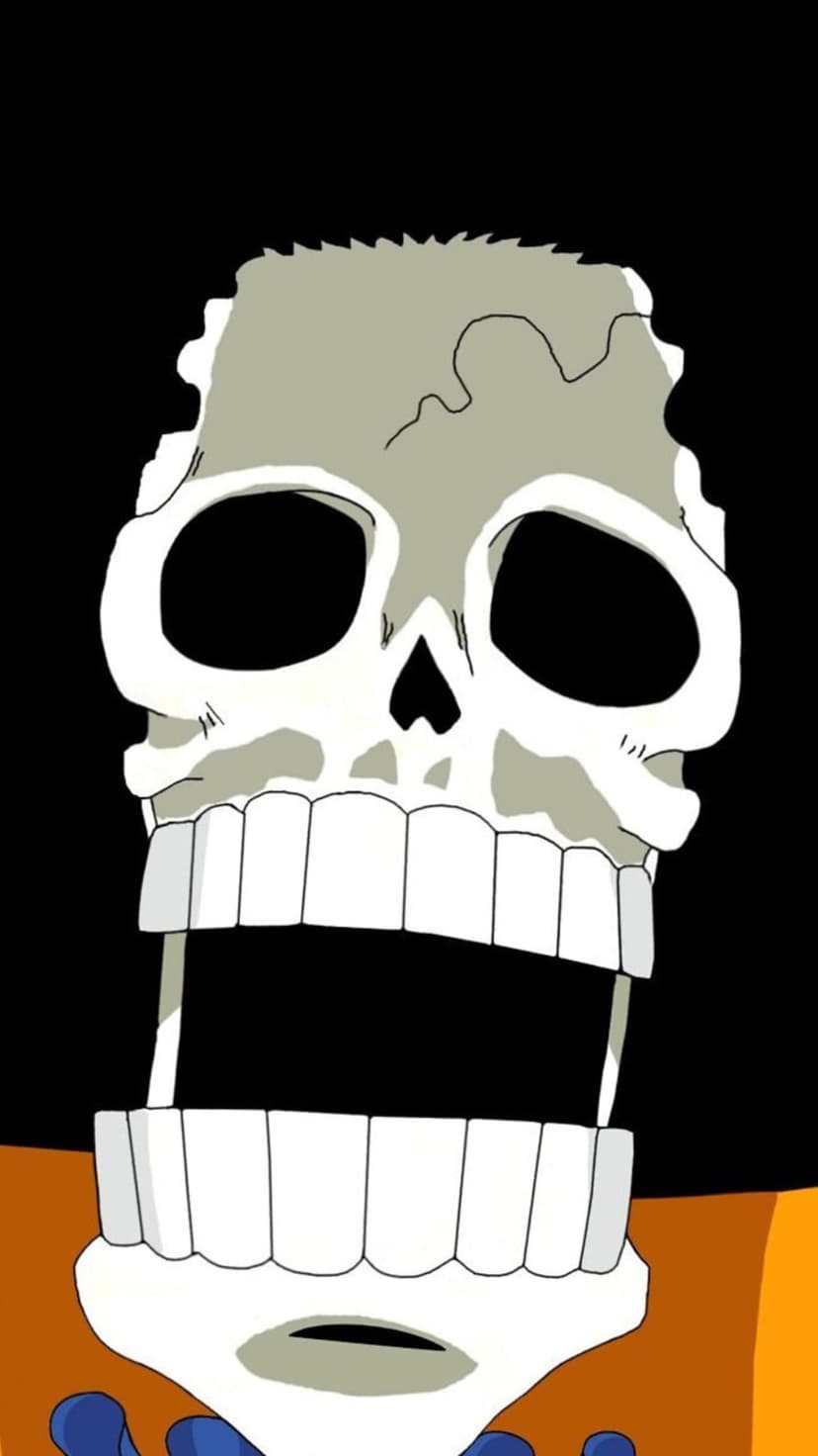 Brook’s gray skull with a wide open jaw and many teeth against a black background with orange clothing visible.