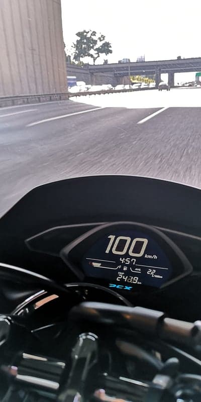 Motorcycle speedometer showing 100 km/h on highway