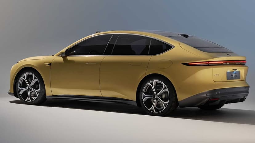 Side and rear profile of a yellow Nio ET5 electric car with slim taillights in a studio setting.