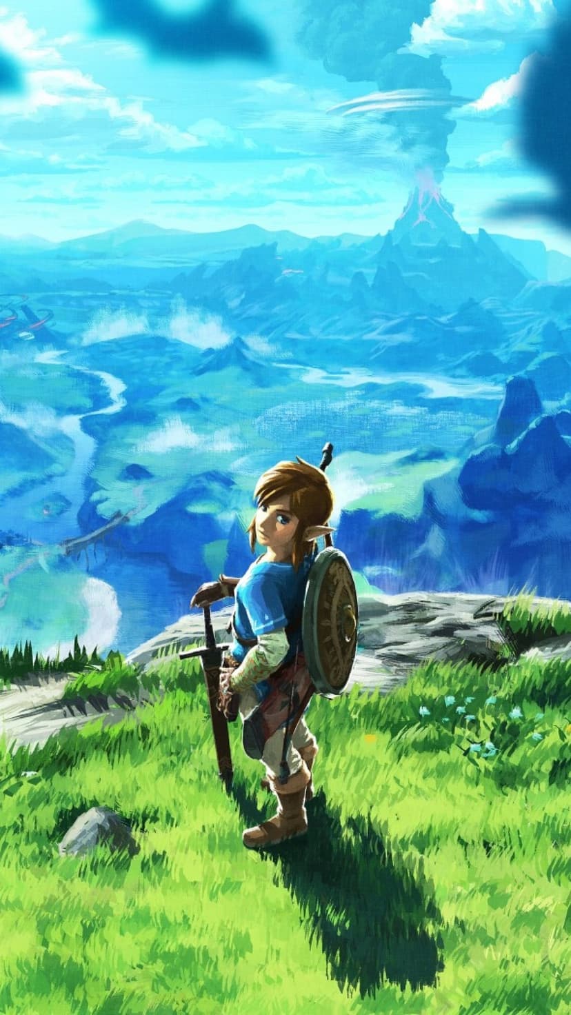 Link on a grassy cliff looking back at a blue mountainous landscape with an active erupting volcano.