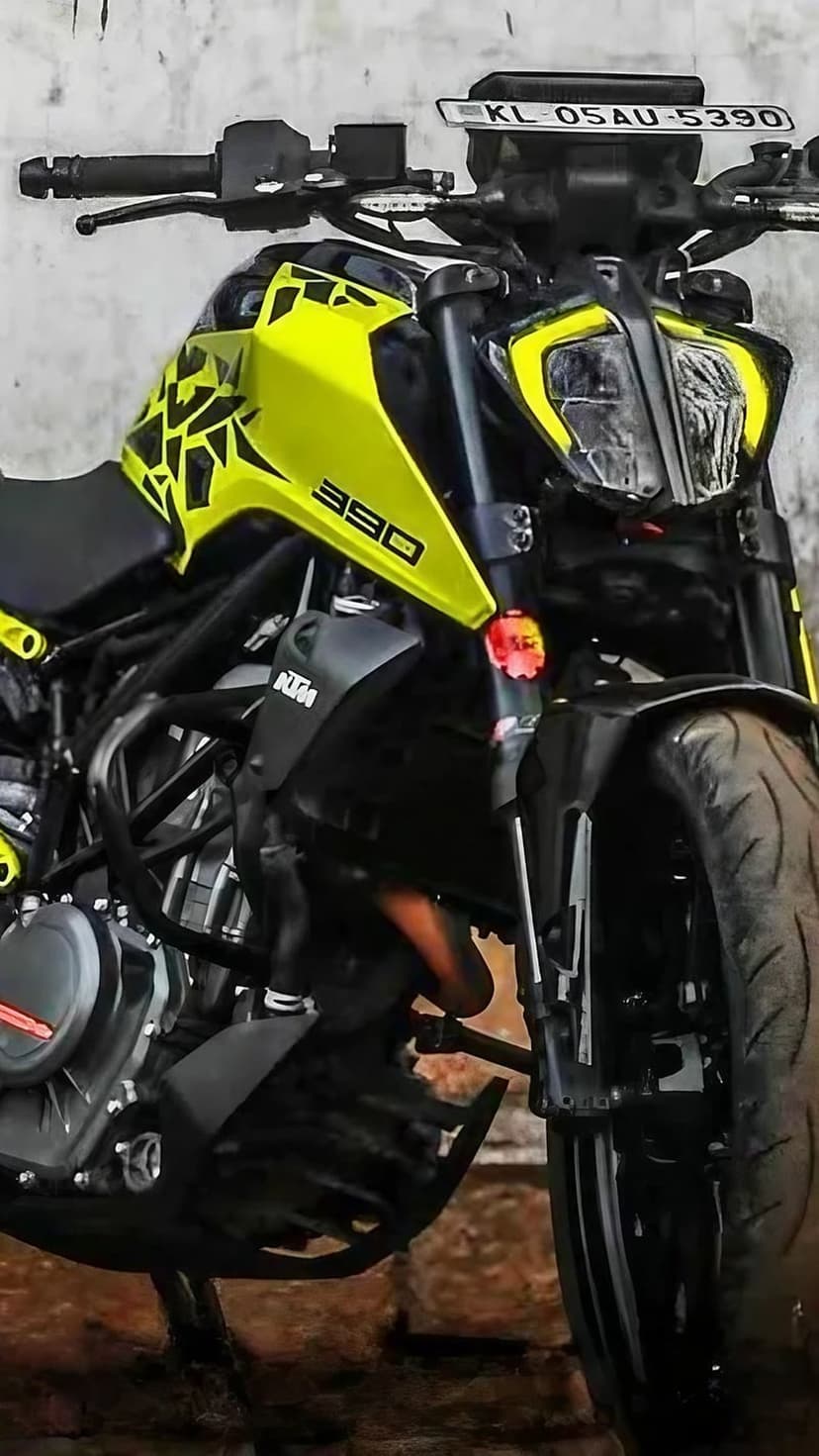 Yellow KTM 390 Duke motorcycle parked against a textured wall with visible decals and black engine components.