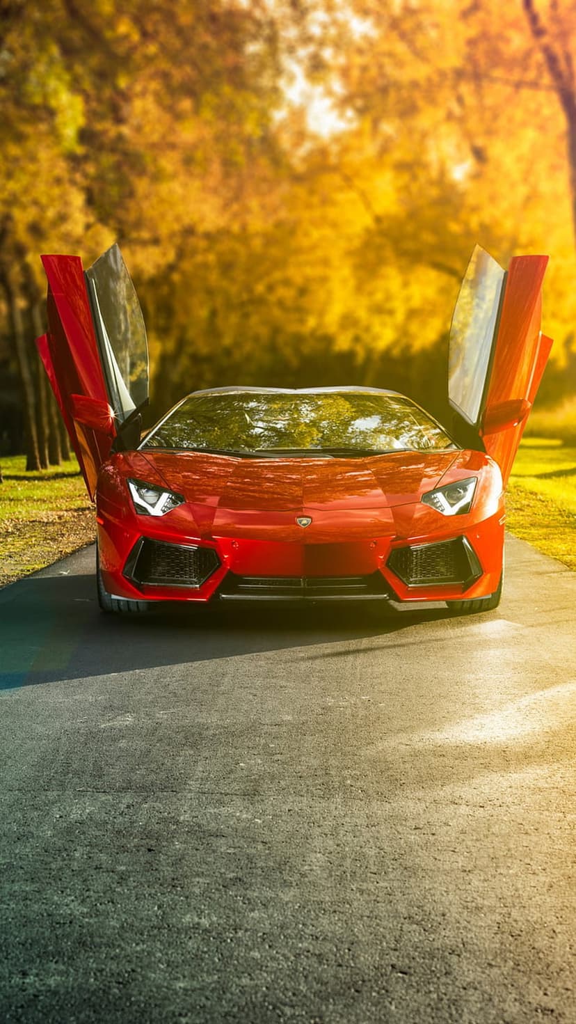Red Lamborghini Aventador with butterfly doors open on a road surrounded by golden autumn forest foliage.