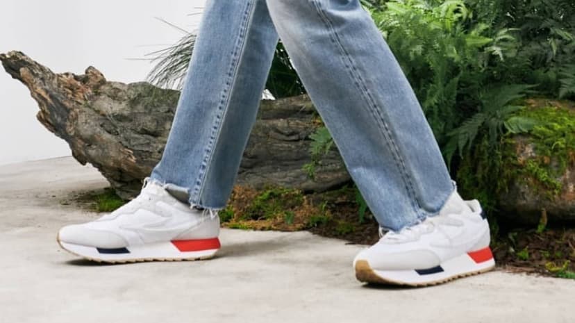 White Fila sneakers with red and blue sole accents shown in a vertical composition for mobile backdrops.