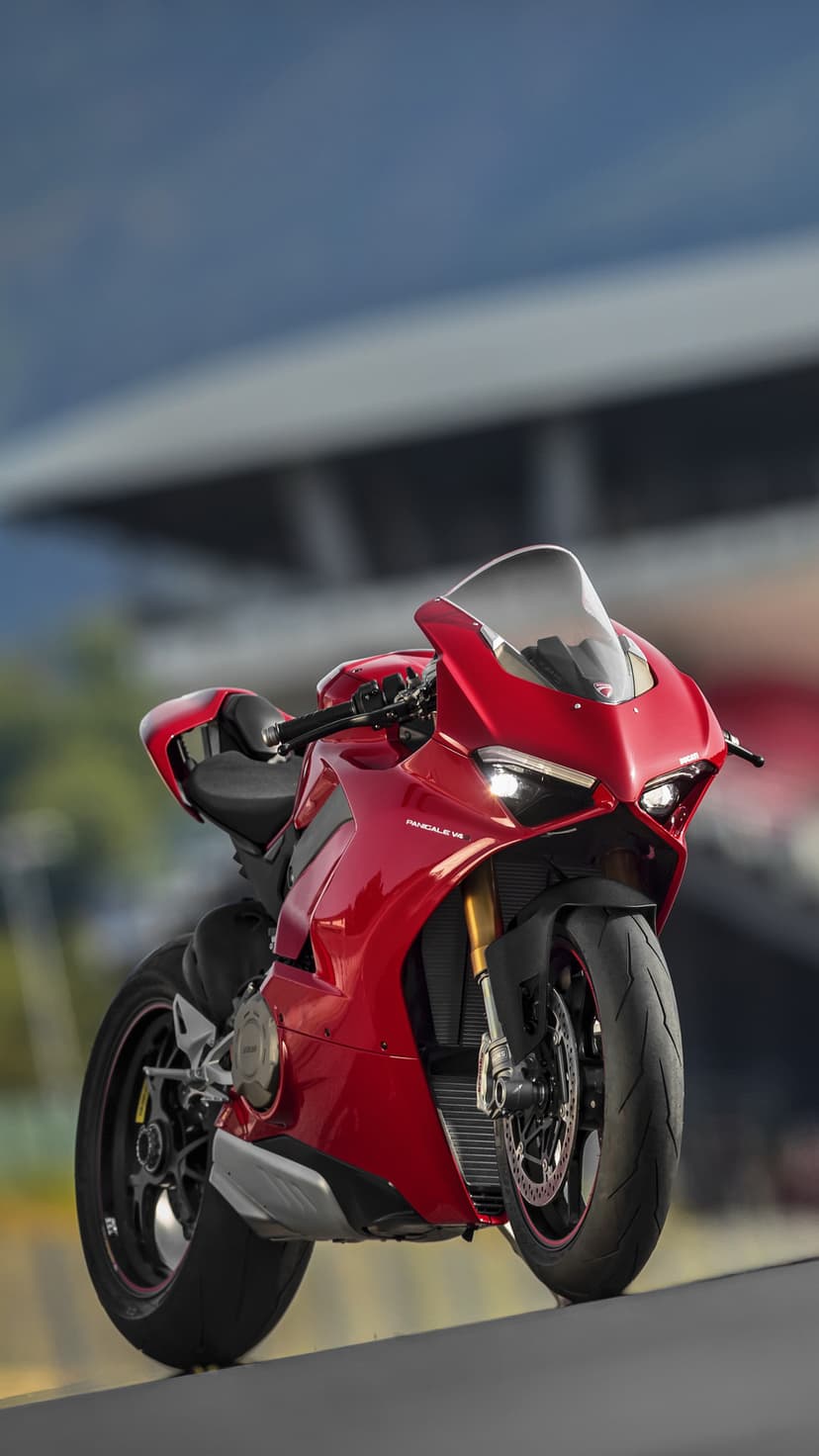 Red Ducati Panigale V4R motorcycle on a racetrack with LED headlights and aerodynamic fairings in a low-angle view.