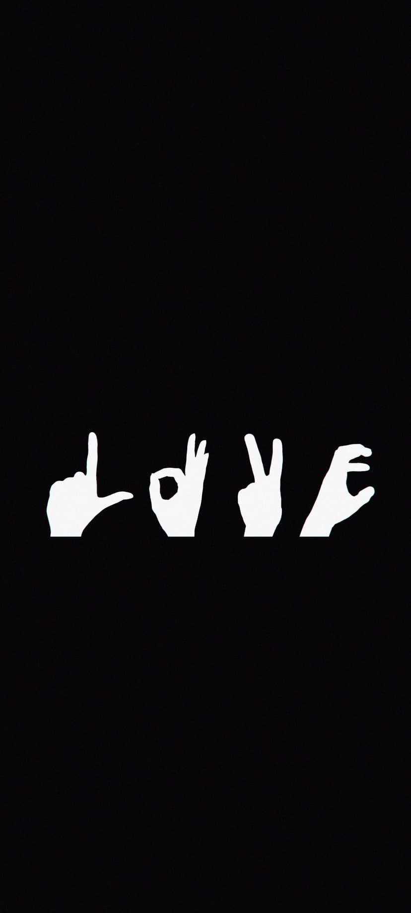 White hands positioned to spell the word love in American Sign Language against a dark, high-contrast backdrop.