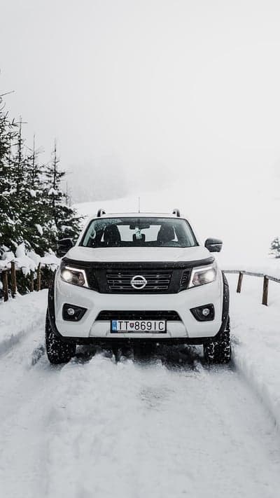 Nissan Navara driving through snow in a forest
