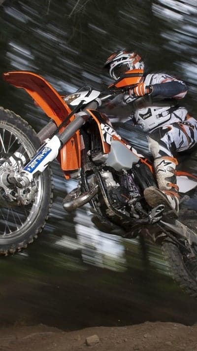 Motocross Rider Forest Jump Action Mobile Wallpaper