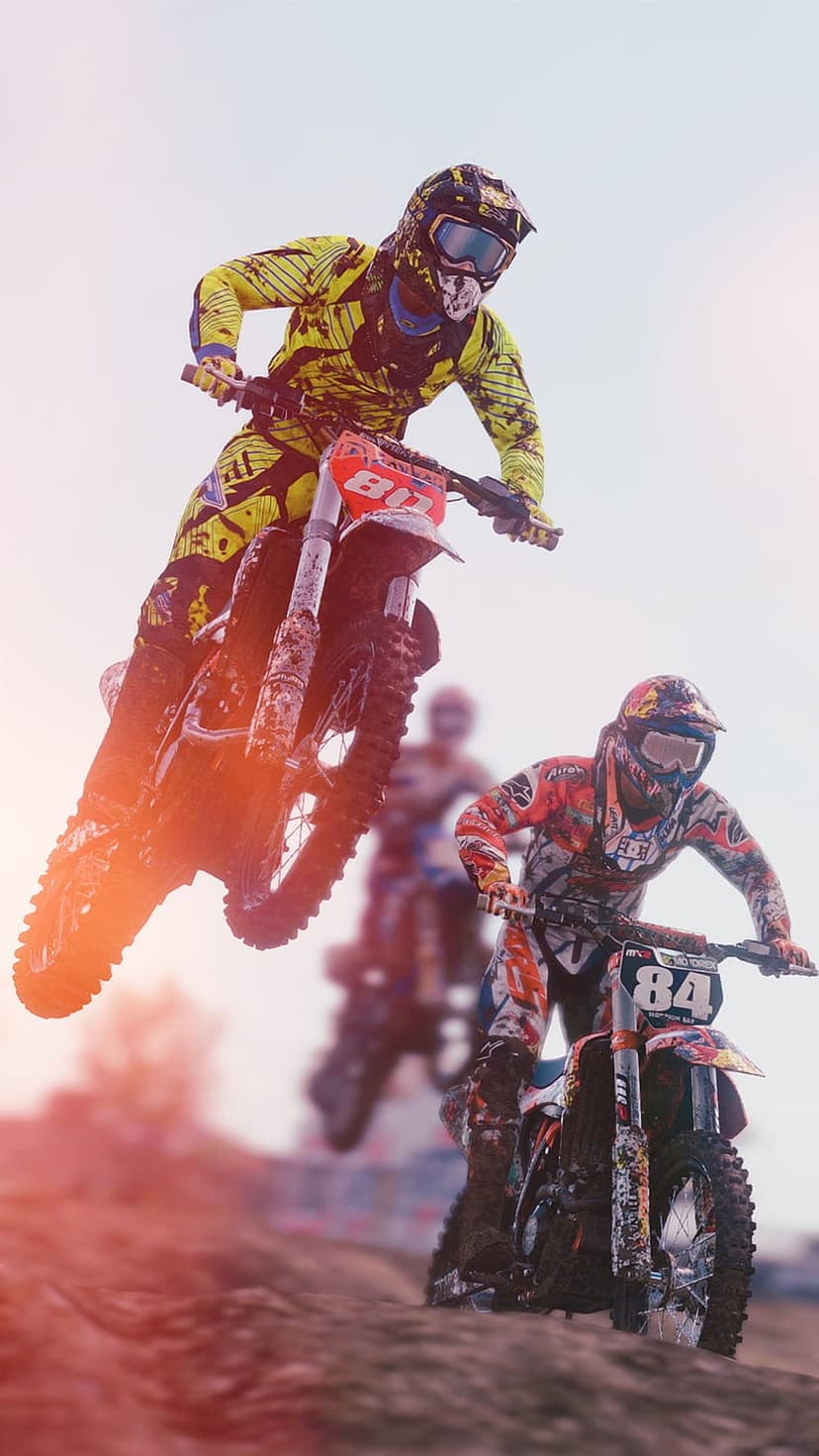 Two motocross riders in colorful gear jump dirt bikes high into a bright sky above a racing track during a race.