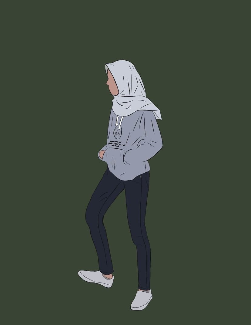 Muslim woman in a grey hijab and hoodie stands in profile against a dark green backdrop wearing white sneakers.