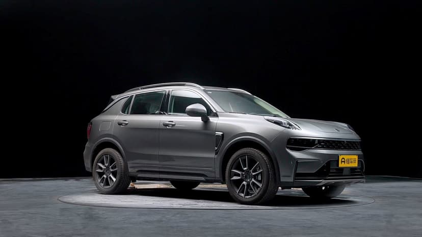 Matte grey SUV on a circular studio platform with a solid black background and subtle reflections.