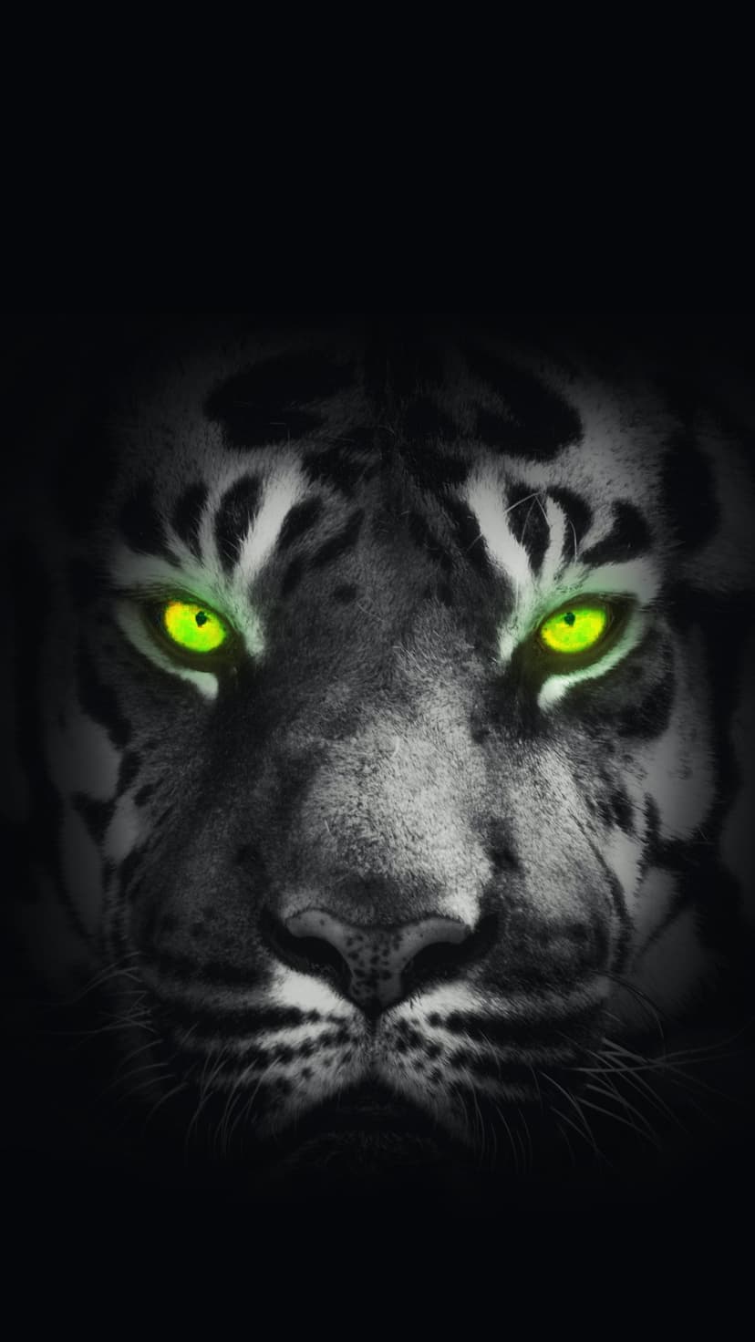 Bengal tiger face in black and white features glowing neon green eyes against a dark, shadowy background.