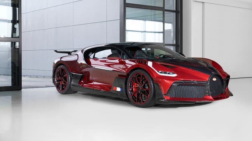 Red and black Bugatti Divo Lady Bug parked in a modern showroom with large windows and soft daylight.