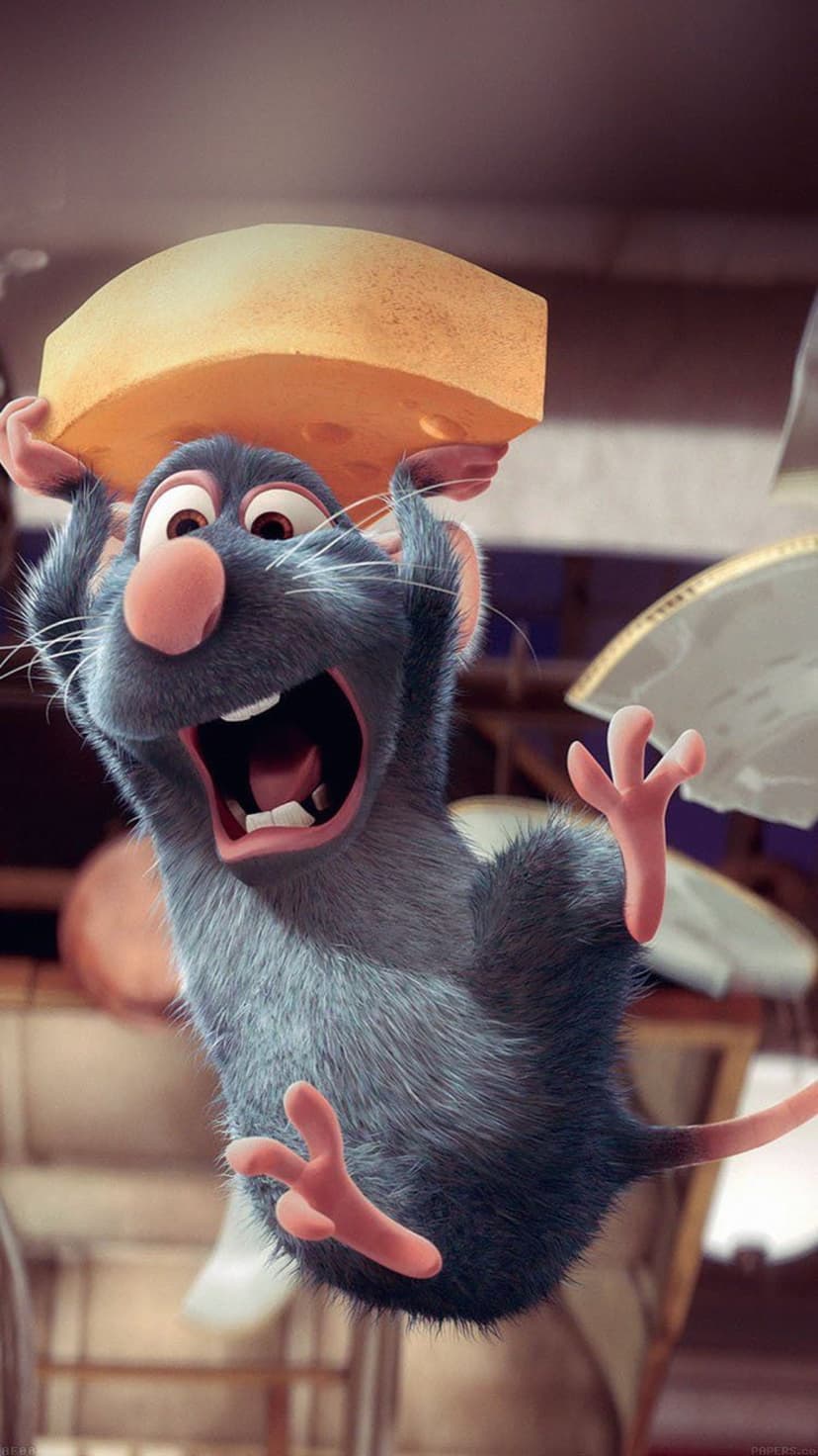 Remy the rat holds a large yellow cheese wedge over his head with a joyful expression in a kitchen setting.