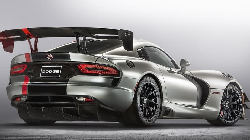 Silver Dodge Viper ACR rear view showing a large carbon fiber wing, red racing stripes, and black performance wheels.