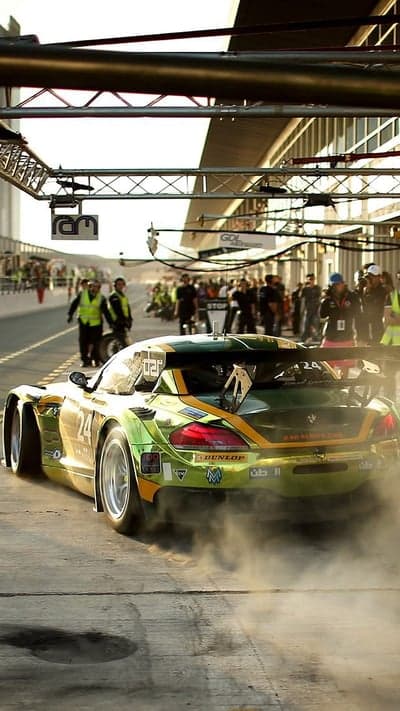 BMW race car leaving pit lane in a cloud of smoke