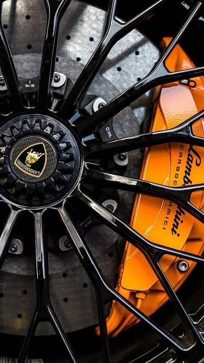 Matte Black Lamborghini Rim with Orange Caliper Background
