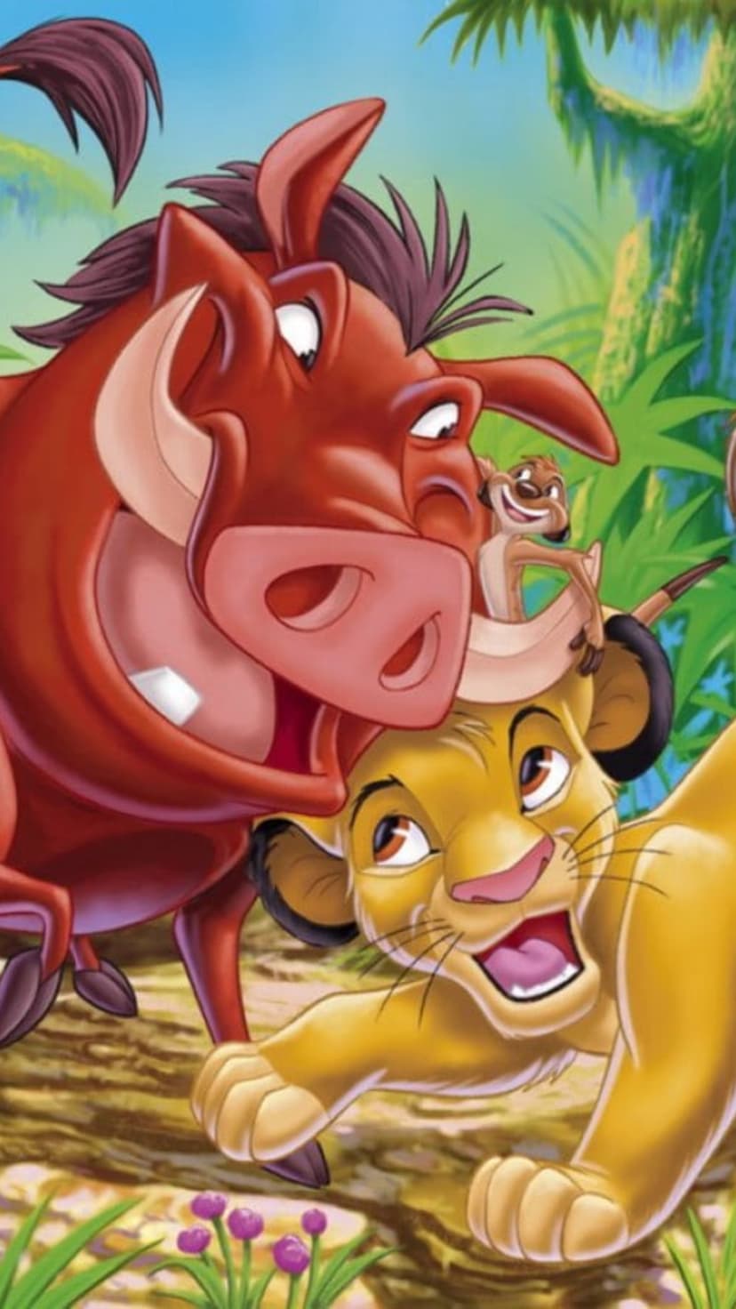 Simba the lion cub walks with Timon and Pumbaa through thick green ferns and tropical jungle vegetation.