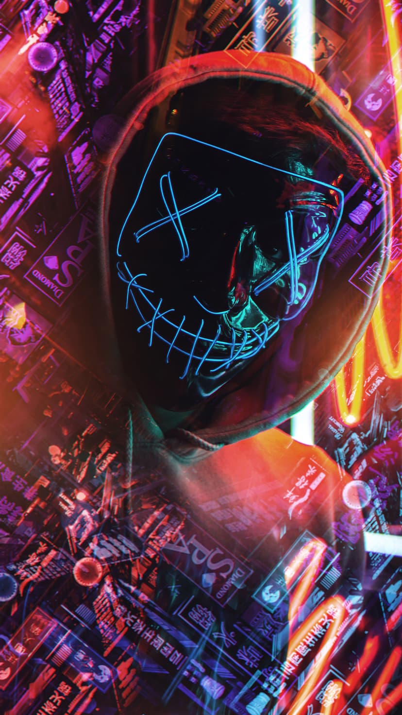 Hooded person wearing a glowing blue mask with X eyes and a stitched mouth amidst red and purple neon lights.