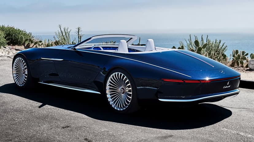 Rear view of a dark blue Mercedes Maybach 6 Cabriolet parked on a coastal road overlooking the ocean.