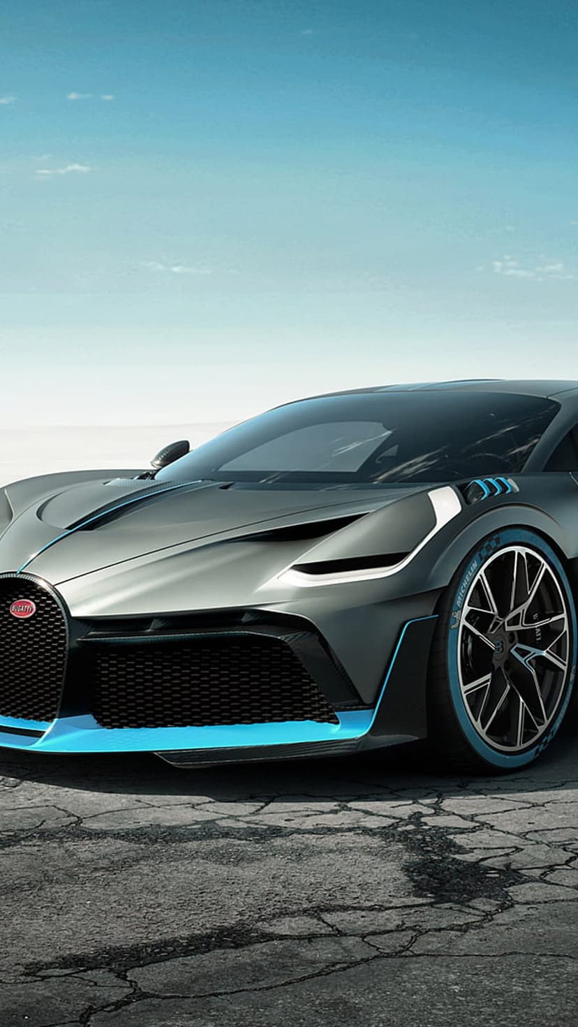 Bugatti Divo hypercar with blue accents on the splitter and rims parked under a clear blue sky during the day.