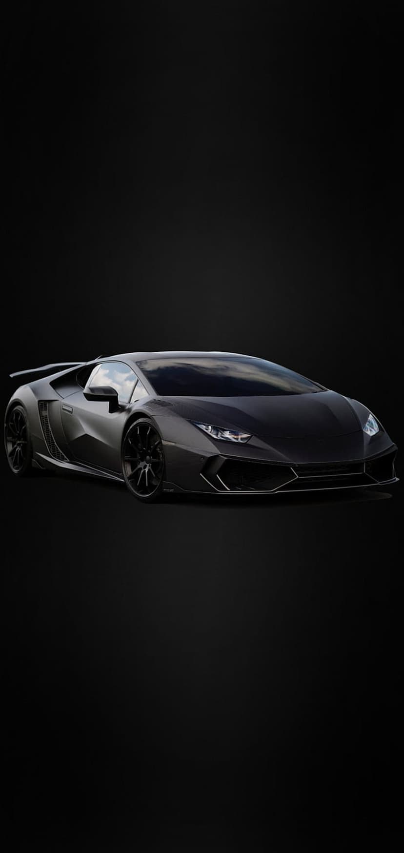 Matte black Lamborghini sports car with sharp body lines and headlights visible against a dark background.