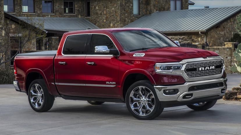 Red Ram 1500 Limited pickup truck with chrome accents parked on a driveway in front of a stone house.