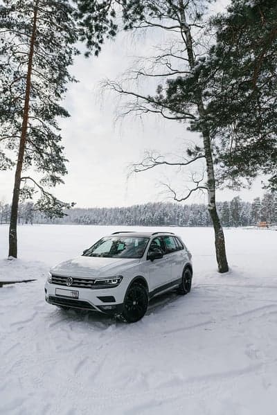 White VW Tiguan SUV in Snowy Winter Woods Mobile Wallpaper