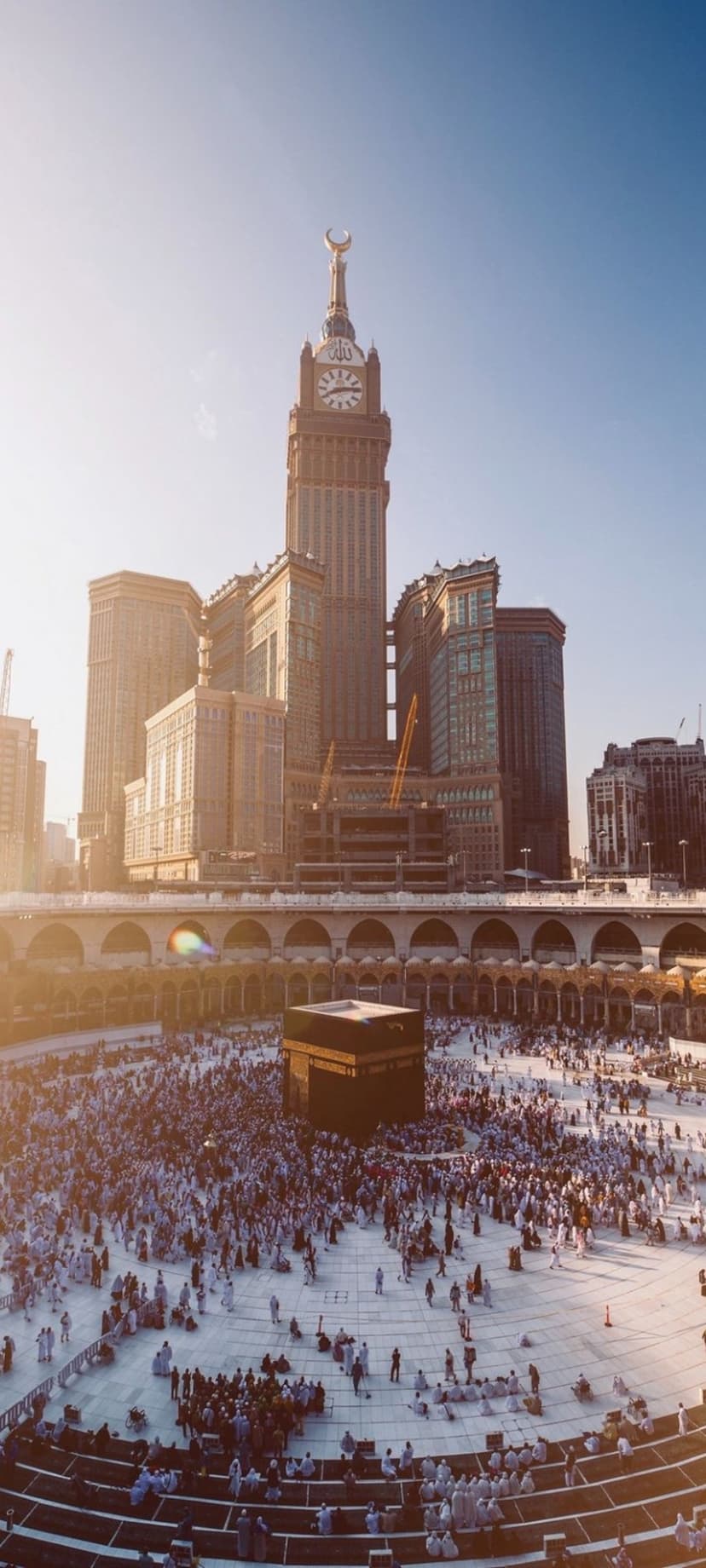 The Makkah Royal Clock Tower overlooks thousands of pilgrims in white ihram circling the Kaaba at Masjid al-Haram.