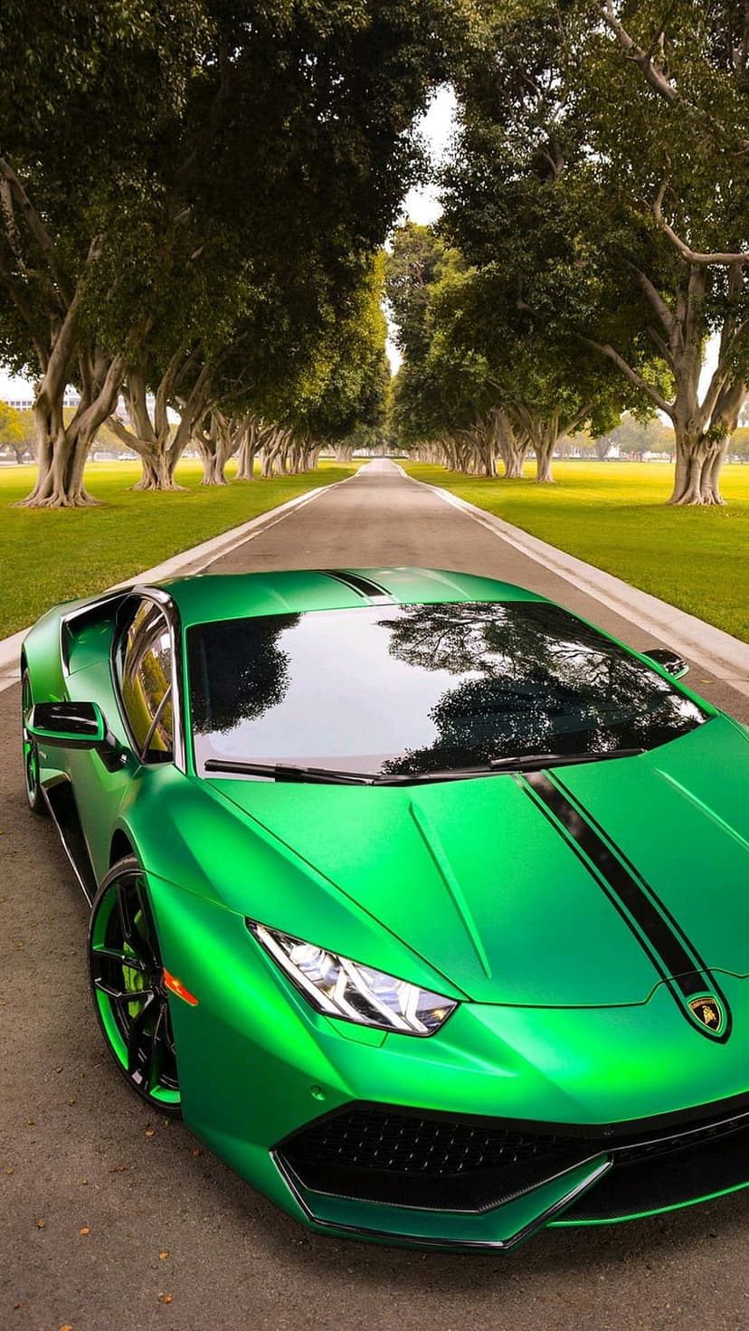 Lime green Lamborghini supercar on an asphalt road surrounded by lush green trees in a vertical perspective.