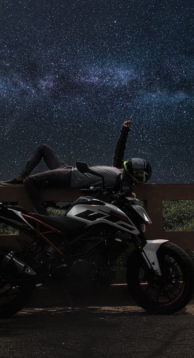 Rider Under Starry Night Sky with Motorcycle